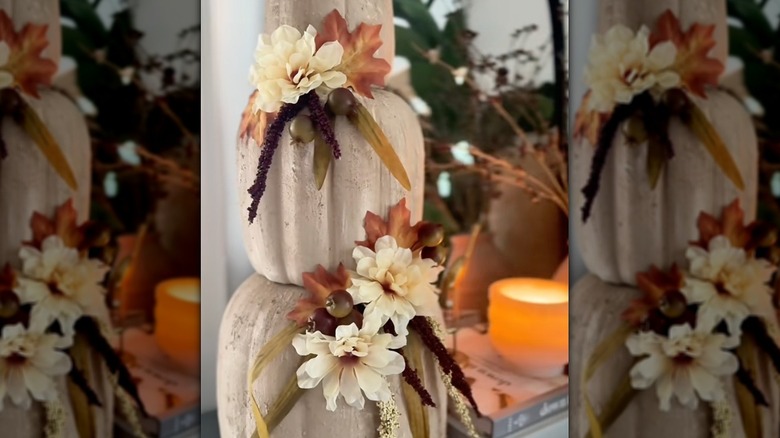 Dollar Tree stackable pumpkins transformed into classier fall decor with beige paint and faux flowers.