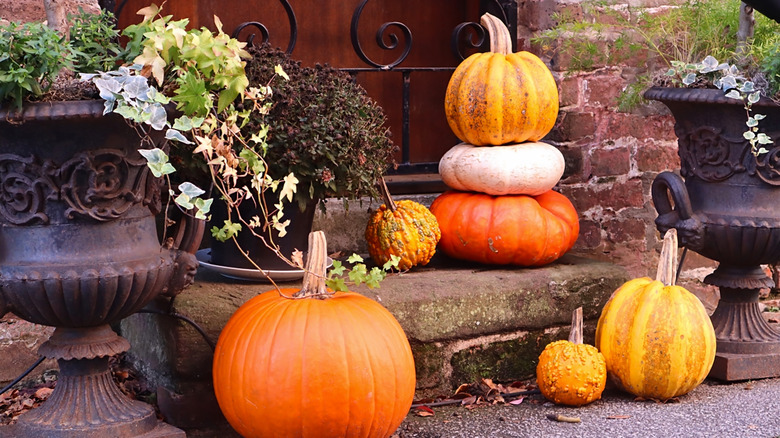A stack of pumpkins on a doorstep