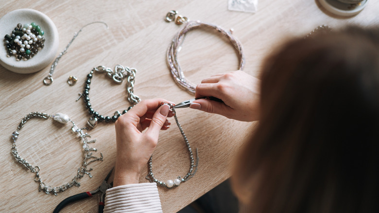 A person making handmade jewelry