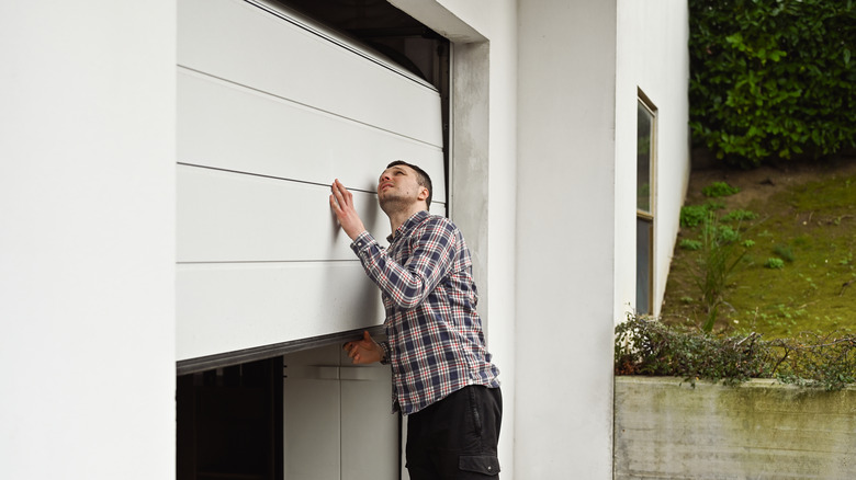 man manually lifting garage door