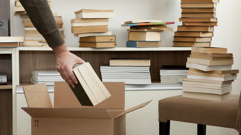 person placing books in box