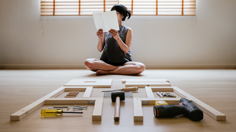 woman building boxed furniture
