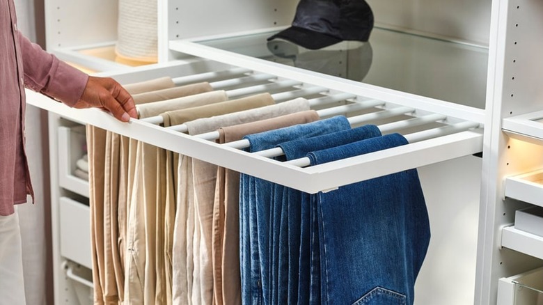 Pants folded over the rods on the IKEA KOMPLEMENT storage rack