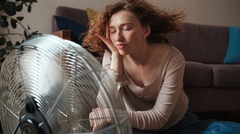 woman cooling down in front of a fan