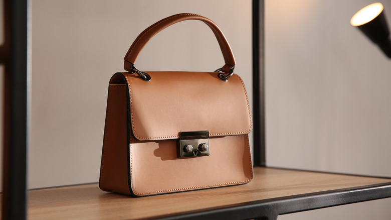 A brown leather purse on a shelf