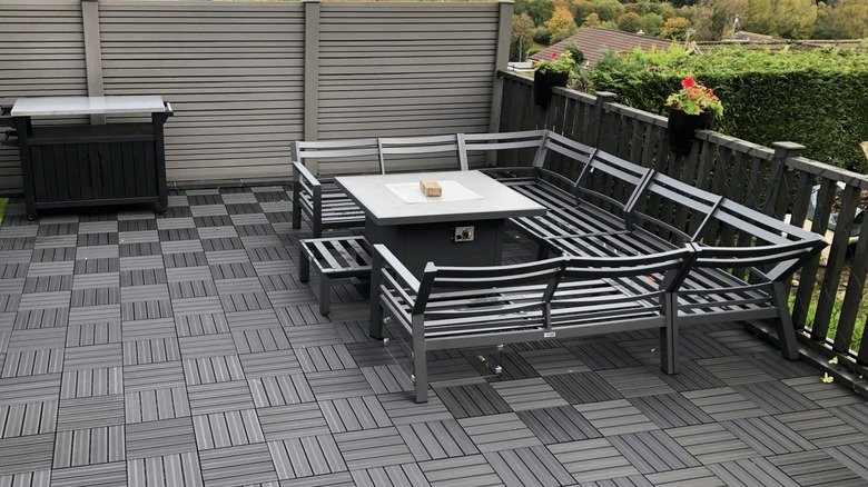A checkered composite decking tile area with seating