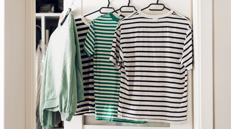 Shirts hanging from hangers in a doorway