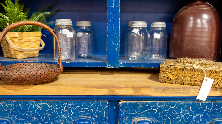 Vintage mason jars on a worn blue dresser
