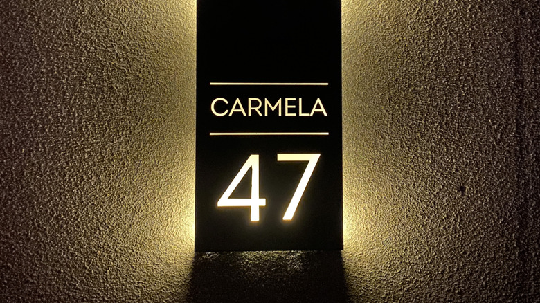 A sophisticated house number lit from behind at night