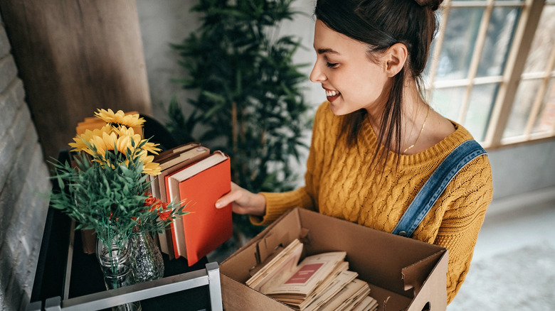 Woman arranging orange books