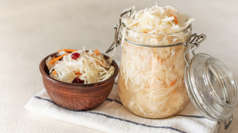 open mason jar filled with cole slaw next to bowl of cole slaw