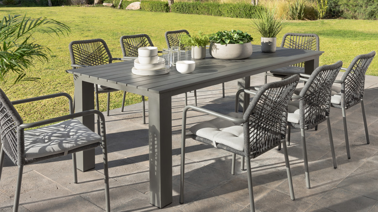 aluminum patio table and accompanying gray rattan chairs