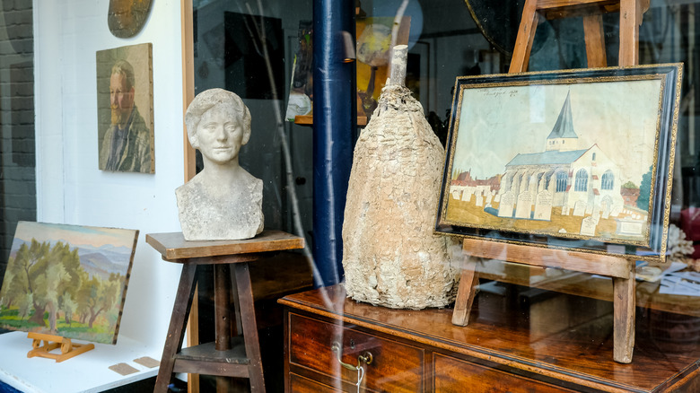 An antique store with vintage art in the front window.
