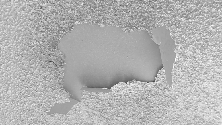 A closeup of a portion of popcorn ceiling that is peeling off and falling apart.