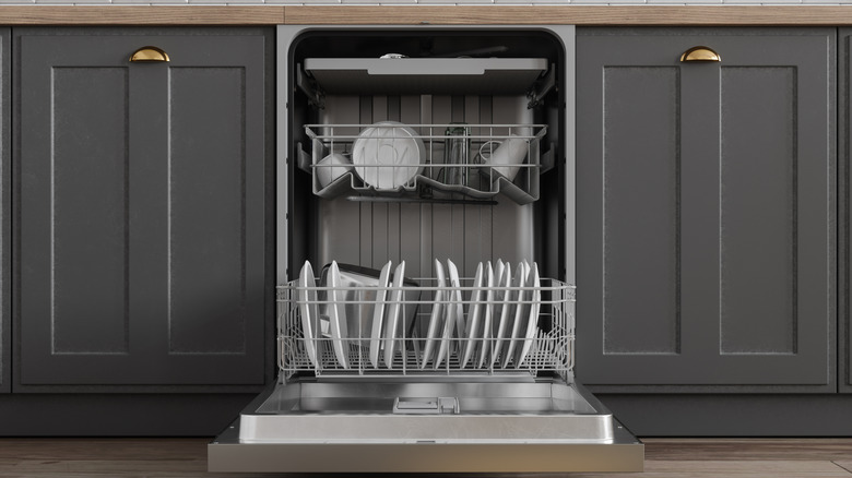 open dishwasher surrounded by gray kitchen cabinets