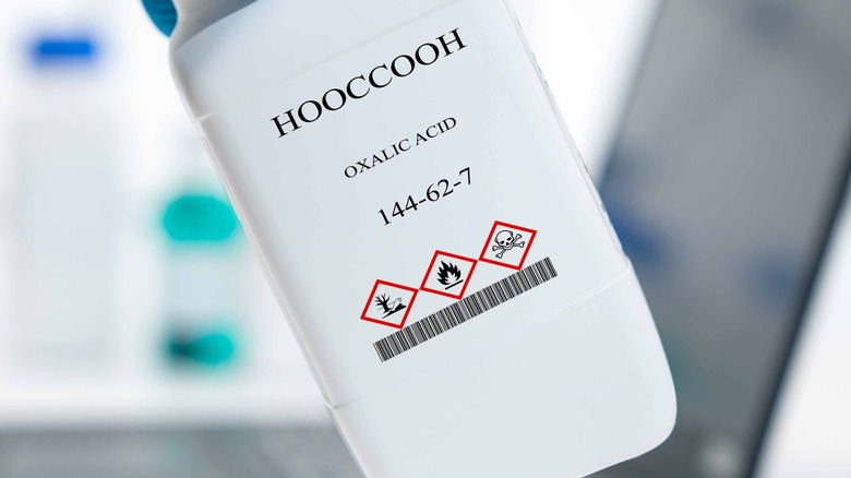 A container of oxalic acid with danger labels