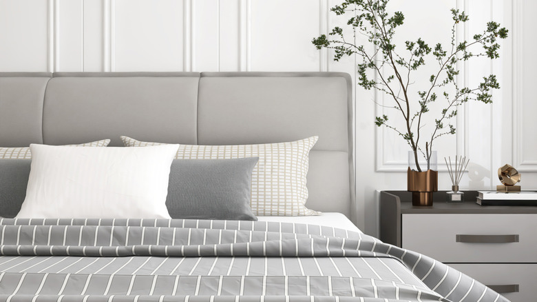 Simple gray headboard behind bed with gray sheets
