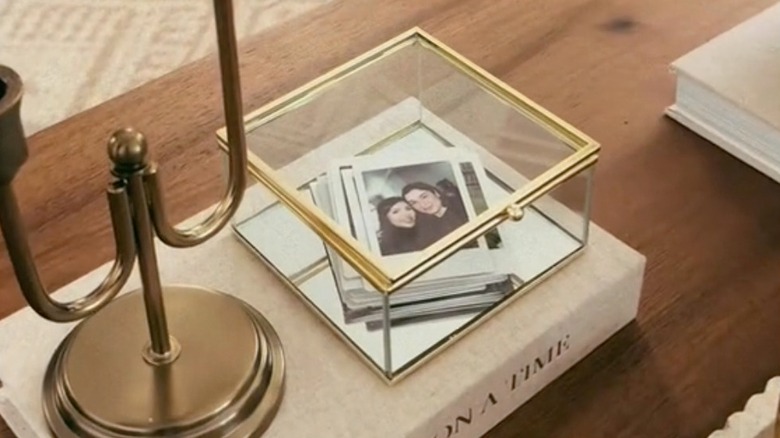 Glass trinket box with gold trim holding photos