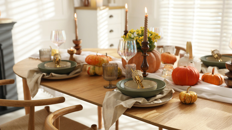 A fall table set-up with pumpkins and candles.