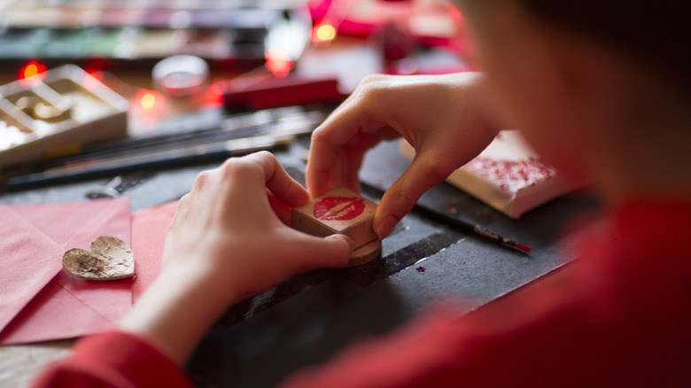 Person stamping books and envelopes with rubber stamps