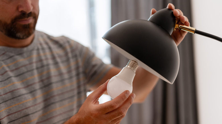 Man installing an LED lightbulb in a lamp