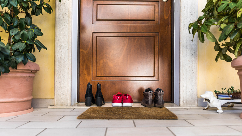 entryway door with doormat and shoes