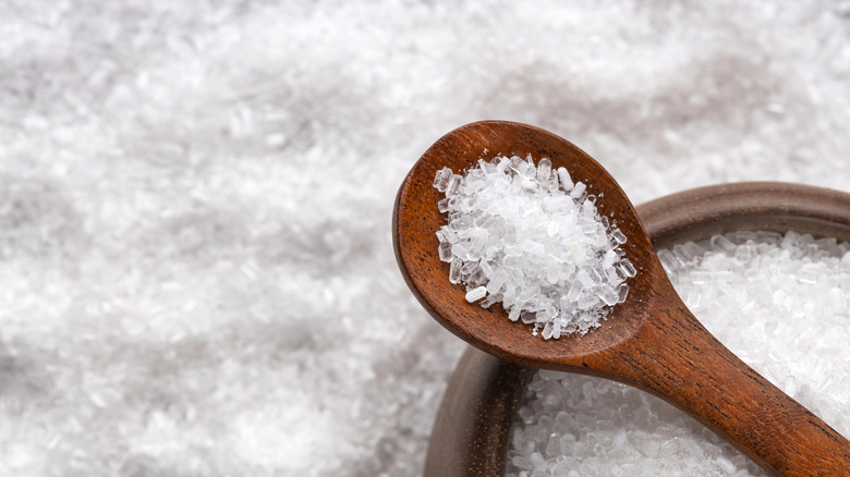 A close-up shot of Epsom salt in a wooden spoon