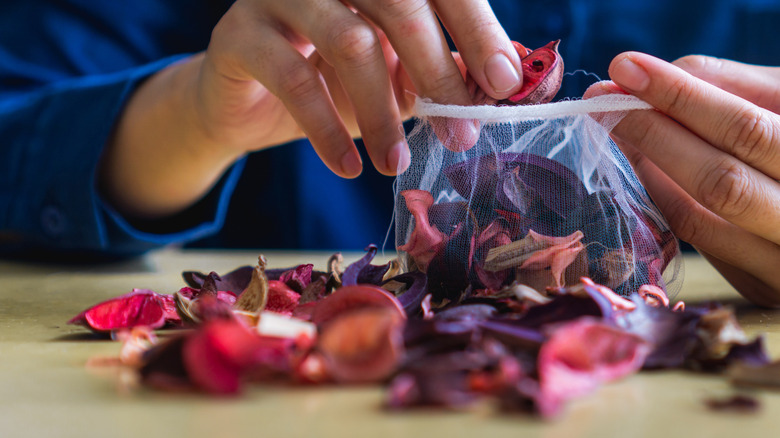 A woman creating a potpourri mixture and putting it into a bag