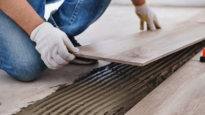 Close up of hands laying tiles