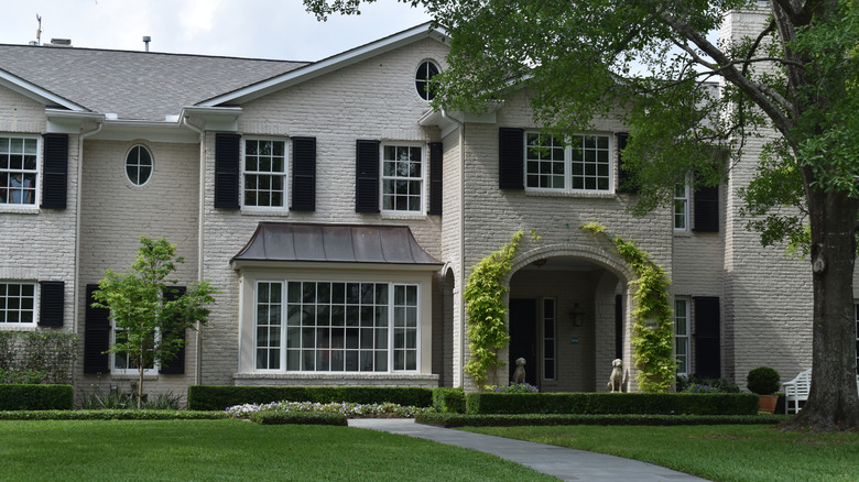 A home has elegant landscaping with climbing vines.