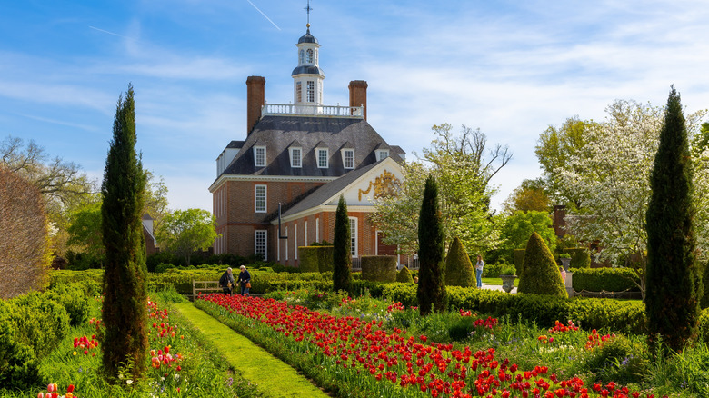 tulip beds and shrubbery in front of a colonial brick building