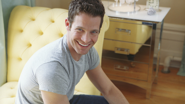 HGTV host and designer Nate Berkus sits on a lemon yellow chaise lounge.