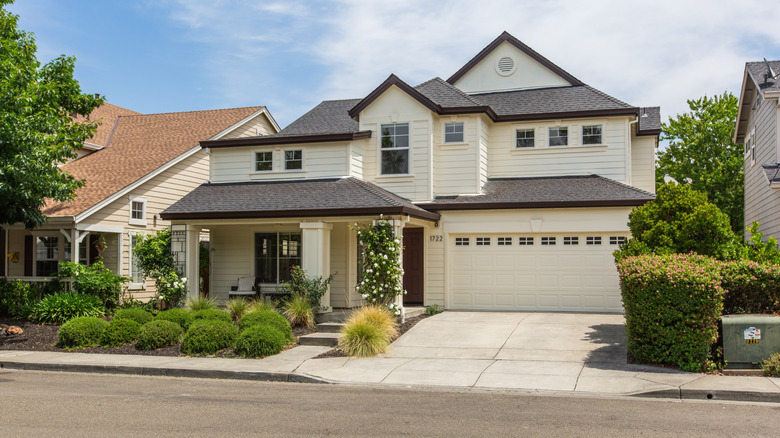 A well-maintained cream colored house with attractive landscaping