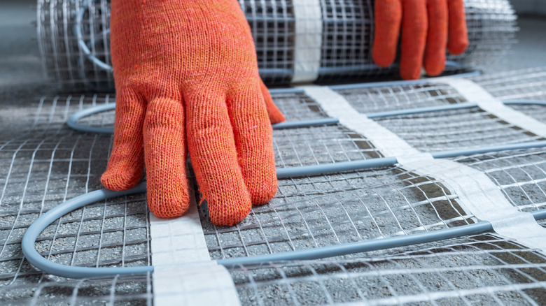 Person installing heated flooring system