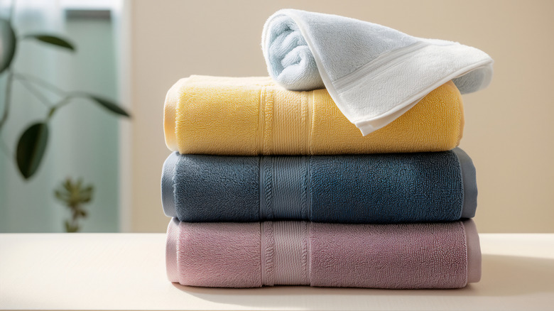 A stack of folded towels with a rolled one on top
