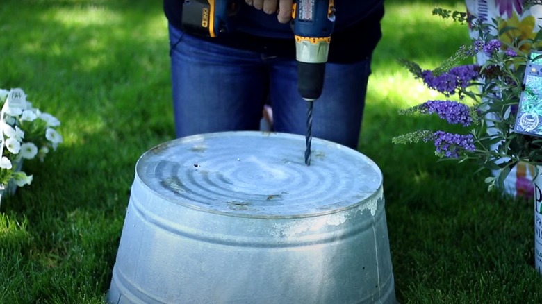 Woman pouring soil into bin 
