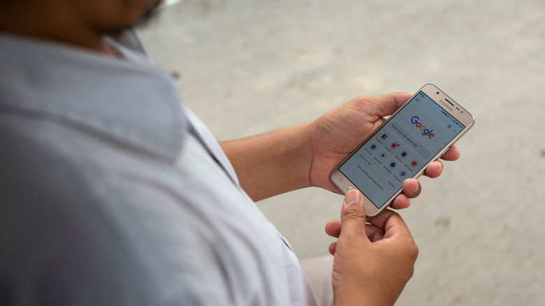 Person holding phone with Google pulled up