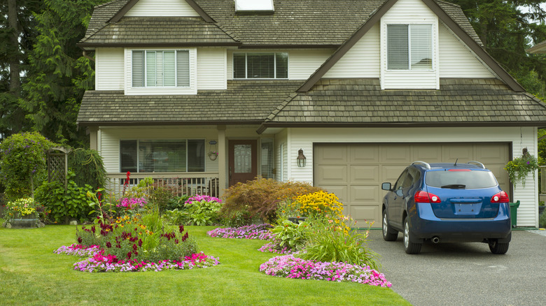 view of house from street with colorful landscape bordering