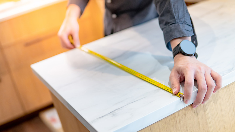 man measuring countertops