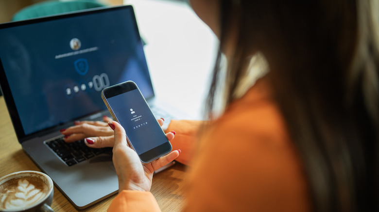 A person enters a password on a phone and keyboard