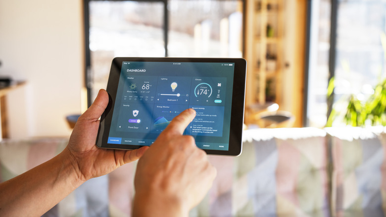 A person uses a tablet to control smart home functions