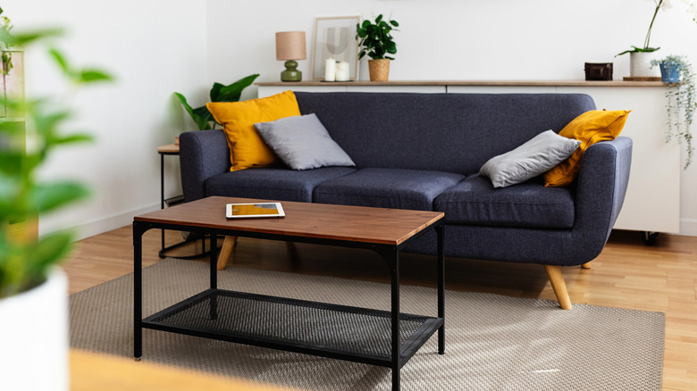 Living room with a navy couch and a dark wood coffee table