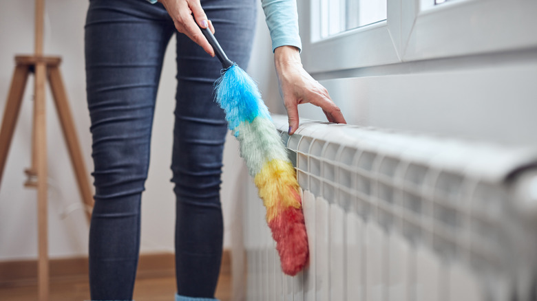 Person dusting a radiator