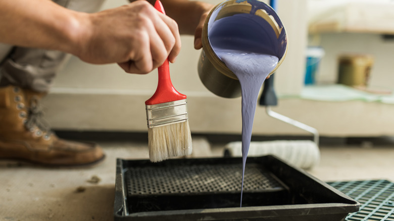 Closeup of man preparing paint for application in home