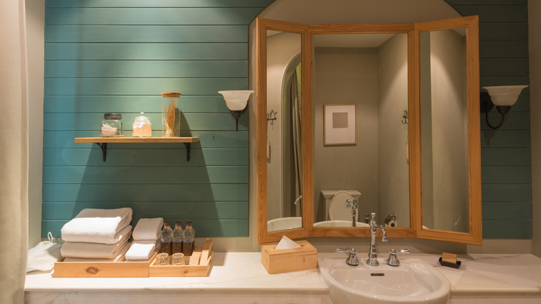 Earthy neutral bathroom with green shiplap and wooden accents