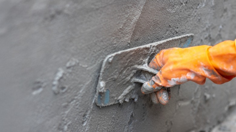 Worker applying cement to a wall.