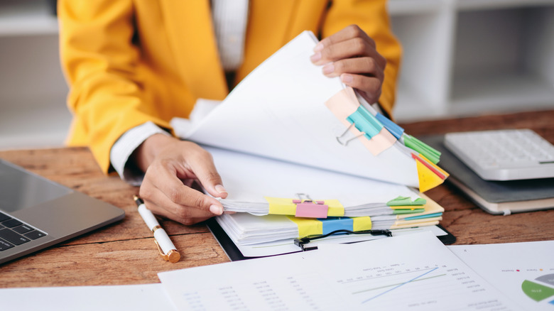 Person organizing papers on desk