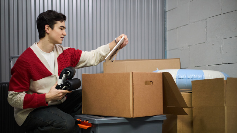 Person in storage unit sorting items and boxes