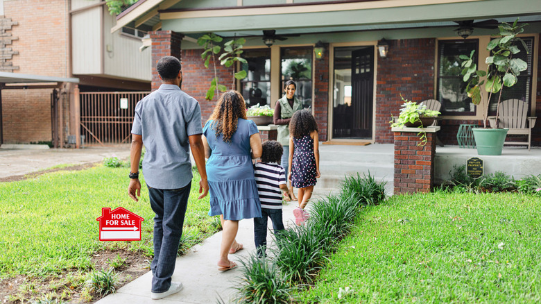Family entering home for sale with real estate agent