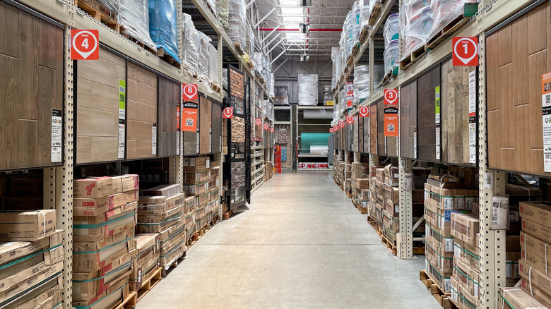 Home Depot flooring aisle with various types of wood-look flooring displays.